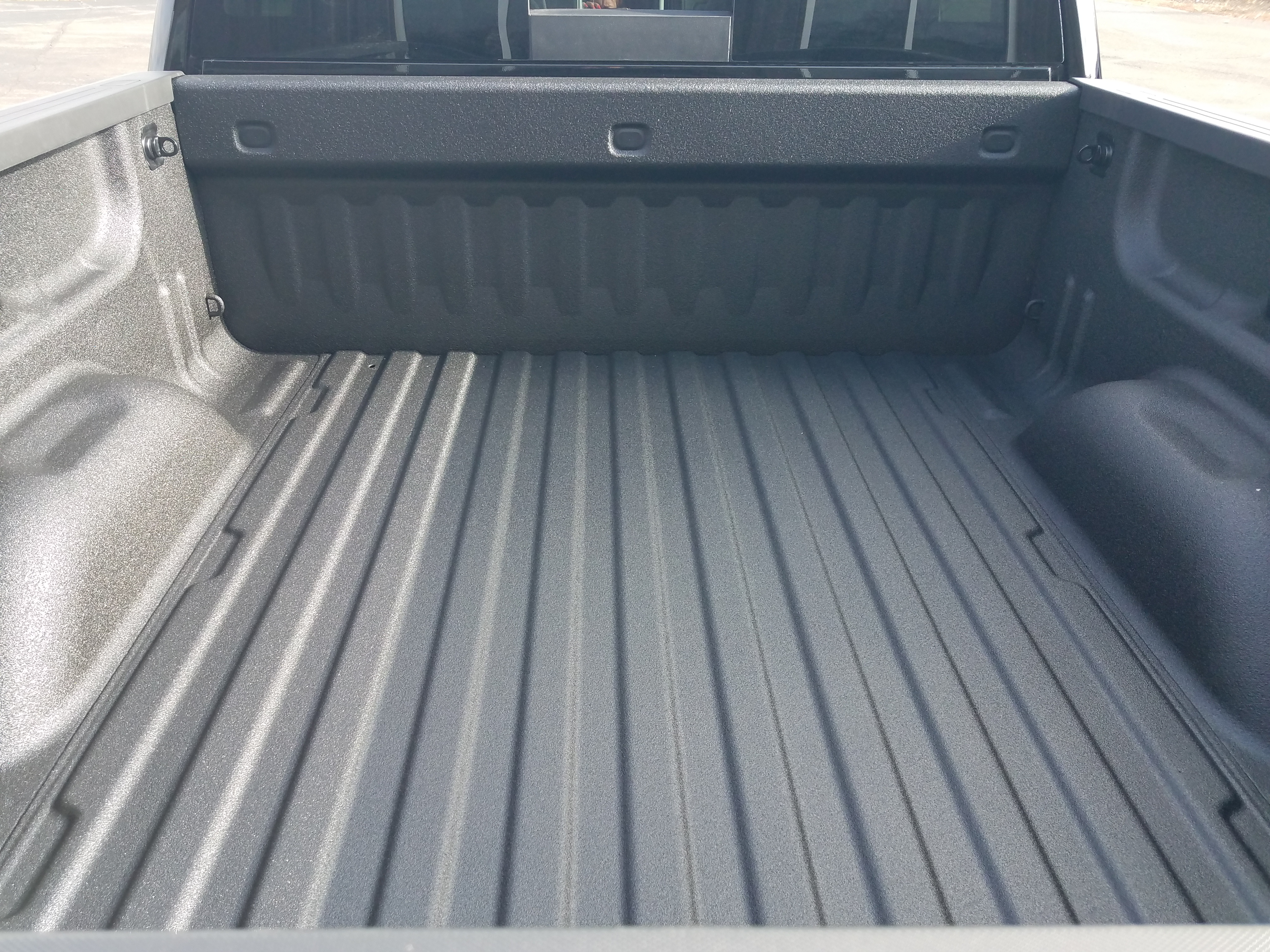Applicator working under a vehicle applying protective coating