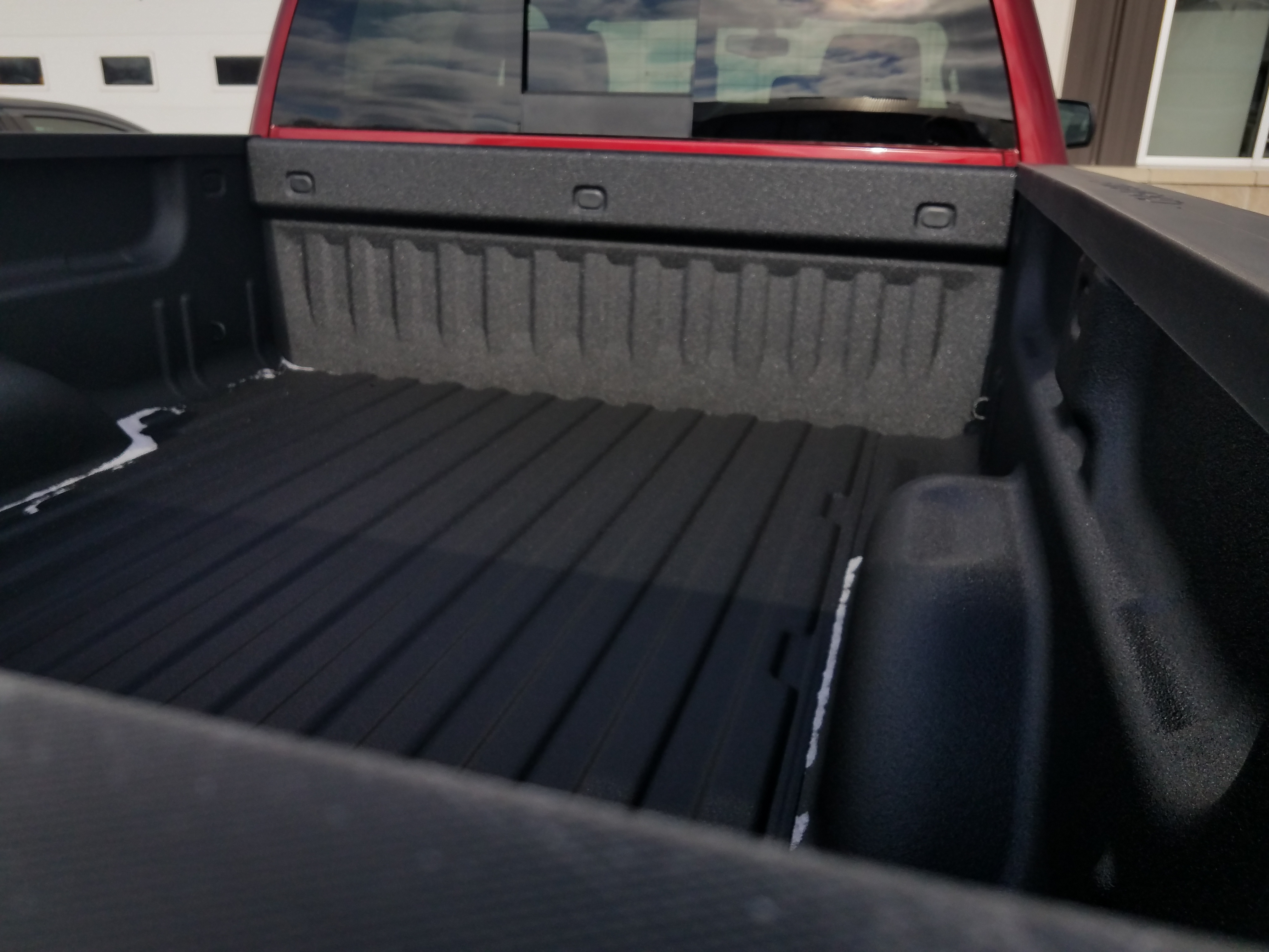 Applicator spraying protective coating in a shop bay